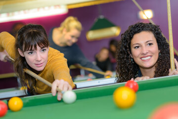 Fototapeta premium two young women playing pool