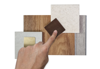 designer's hand choosing interior design material samples for architecture decoration consists wooden vinyl flooring tiles, stone tile, quartz, stainless isolated on background with clipping path.