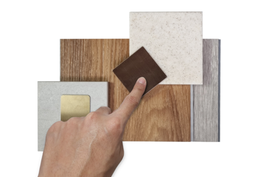 designer's hand choosing interior design material samples for architecture decoration consists wooden vinyl flooring tiles, stone tile, quartz, stainless isolated on background with clipping path.