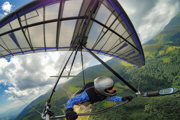Girl hang glider pilot soars in the mountains