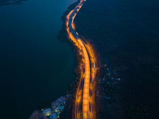 aerial view orange lights on the expressway along the route along the Lam Ta Khong Dam..beautiful scenery in the early morning .wind mill on the mountains, rivers and sweet skies background.