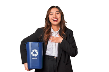 A young business asian woman holding a paper bin for recycle A young business asian woman holding a paper laughs out loudly keeping hand on chest.