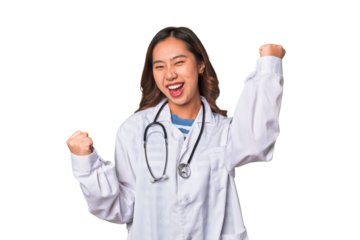 A young asian doctor woman raising fist after a victory, winner concept.