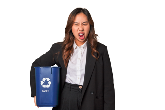 A young business asian woman holding a paper bin for recycle A young business asian woman holding a paper screaming very angry and aggressive.