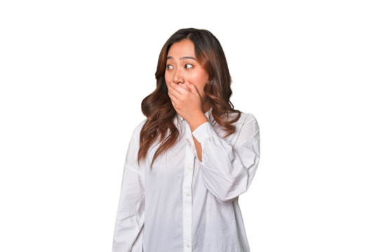 A young chinese woman thoughtful looking to a copy space covering mouth with hand.