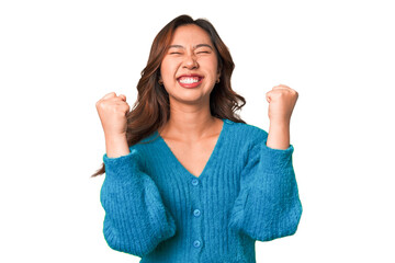 A young chinese woman celebrating a victory, passion and enthusiasm, happy expression.
