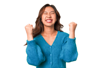 A young chinese woman celebrating a victory, passion and enthusiasm, happy expression.