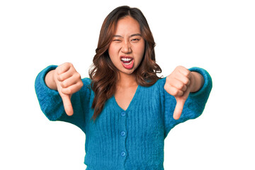 A young chinese woman showing thumb down and expressing dislike. © Asier
