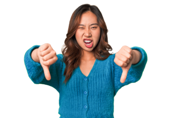 A young chinese woman showing thumb down and expressing dislike.