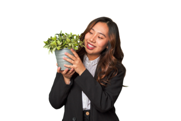 A powerful Chinese businesswoman holds a thriving plant, symbolizing her commitment to sustainable and responsible business practices.