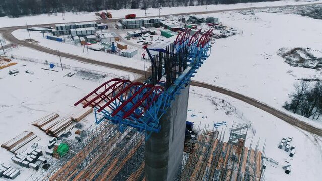 Concrete support column with metal frame at bridge construction site on winter day aerial view. Building of transport infrastructure
