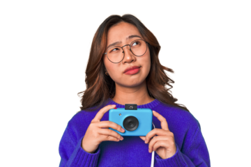 Happy Asian woman holding a retro camera.