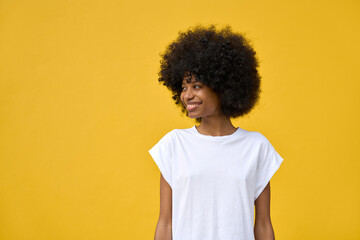 A portrait of young happy smiling woman with big afro hairstyle on her head on yellow orange...
