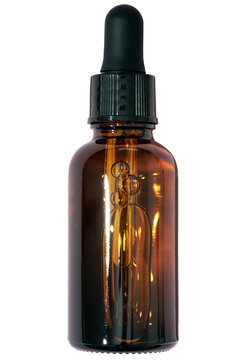 Dark brown glass dropper bottle for serum or essential oil isolated on transparent background. Close-up of face skincare cosmetic product.