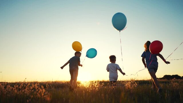 happy family. children a kid together run in park with balloons silhouette. people in park. children and son run. happy family and little baby child summer. kid dream concept. children fun run
