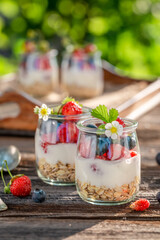 Tasty and sweet granola in jar with yoghurt.