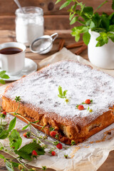 Traditional apple pie on a white plate on a wooden table. Charlotte pie on a platter. Delicious homemade pastry on the table. Top view