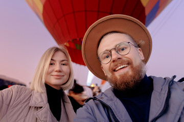 Happy man hipster making selfie photo on phone background hot air balloons in Cappadocia. Concept...