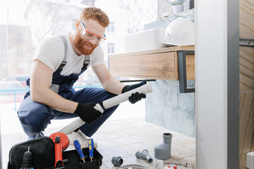 Plumber man at work in bathroom, fix repair service. Concept assemble and install plumbing