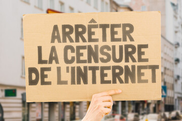 The question " Stop online censorship!" on a banner in men's hands with blurred background. Silence. Regulation. Human rights. Freedom. Free speech. Internet. Network. Violation
