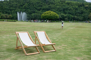 sunbed deck chairs on green grass in outdoor park