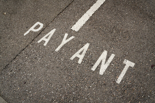 Markierung auf einer Straße in Colmar mit dem französischen Wort Payant. Übersetzung: Gebührenpflichtiger Parkplatz