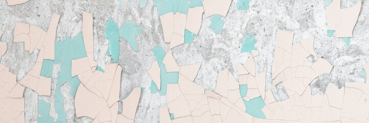 Peeling paint on the wall. Old concrete wall with cracked flaking paint. Weathered rough painted surface with patterns of cracks and peeling. Grunge texture for background and design. High resolution.