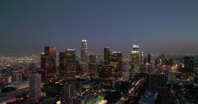 Los Angeles skyline aerial drone night downtown. Aerial shot of downtown Los Angeles skyscrapers at night. City lights and building towers from a drone with urban streets and traffic.