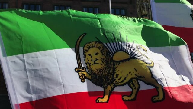 Iran waving pre-revolutionary Lion and Sun flag. Close up film clip. The Lion and Sun symbol dates back to 12th century Persia.