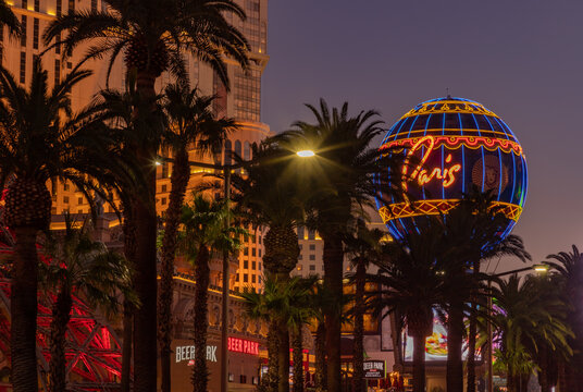 Las Vegas, United States - November 23, 2022: A picture of the Paris Las Vegas Balloon Sign and the nearby palm trees at sunset.