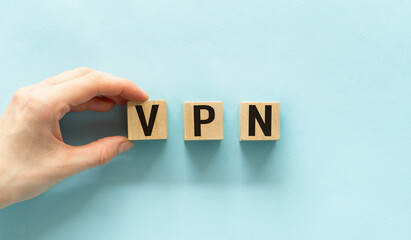 Hand holding wood cube block with VPN text. VPN - short for Virtual Private Network