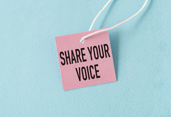 Share Your Voice text quote on a pink card, Business Concept on Blue Background.