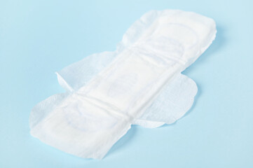 Close-up white clean women's pads isolated on blue pastel color background. The concept of women's health and menstruation