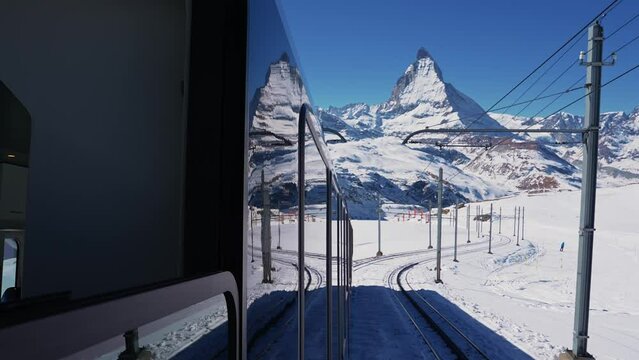 Riding the iconic cogwheel Gornergrat railway in Zermatt ski resort in the Swiss Alps in Valais, Riding a train in Switzerland on a sunny winter day