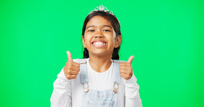 Portrait, children and thumbs up with a girl on a green screen background in studio wearing a princess tiara. Kids, thank you and emoji with an adorable little girl child saying yes in agreement - Powered by Adobe