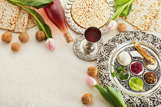 Passover Seder plate with traditional food, walnuts, matza and wine on grunge background