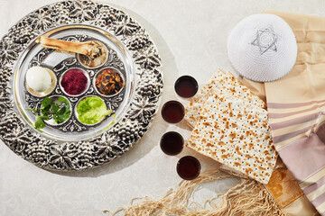 Passover Seder plate with traditional food, walnuts, matza and wine on grunge background