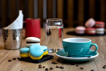 Cakes and a blue cup with coffee on the table.