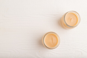 Baby puree with fruits mix, apple, banana infant formula in glass jar on white, flat lay, copy space