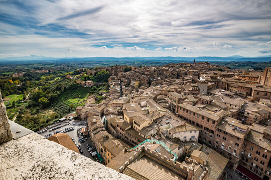 Siena, Tuscany, Italy, scenery elevated partial view of the city with dramatic clouds in the autumn sky. Amazingly beautiful cityscape of Tuscan travel destination