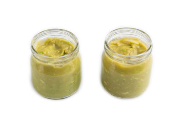 Baby puree with vegetable mix, broccoli, avocado in glass jar isolated on white, side view