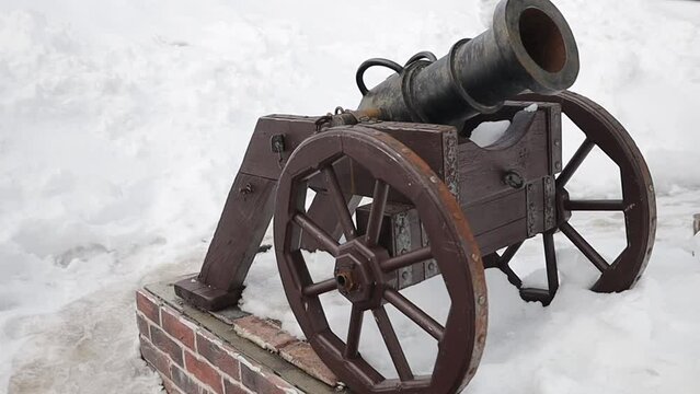 vintage cannon with wheels on the street in winter