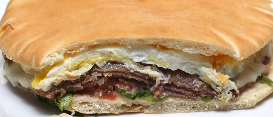 Fototapeta premium meal called beirute with Arabic bread, egg, roast beef and vegetables. meal details. food texture.
