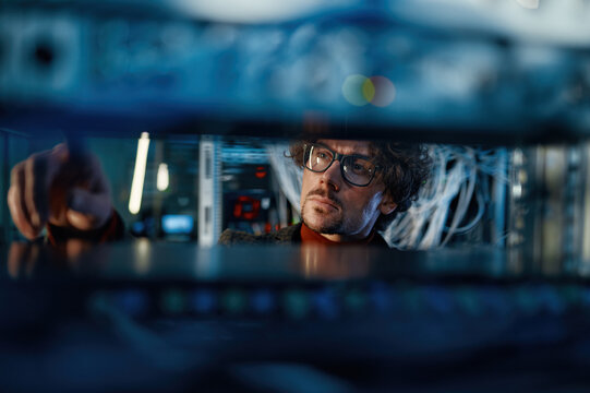 Male IT professional working in server room selective focus