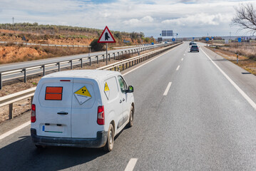 Van with orange plates of dangerous goods and with danger tags by radioactivity, circulating on the...
