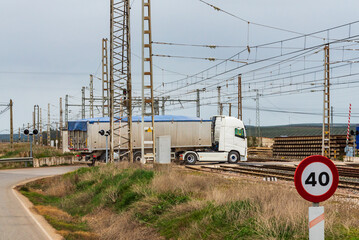 Truck crossing the train roads through a level regulated by Semaforos.