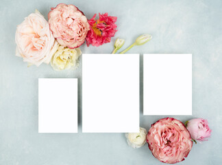 Bridal flat lay with three blank cards and fresh roses on light blue background