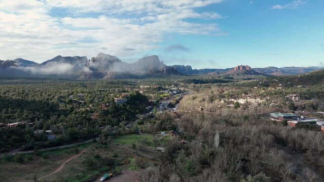 Aerial view of the mountains in Sedona, AZ covered with white clouds.