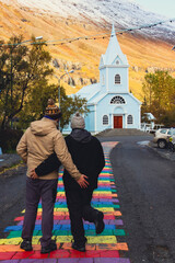 Couple walking across the multicolored crosswalk