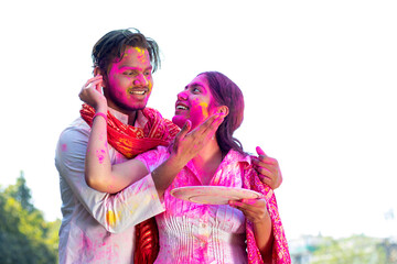 Both putting colour on a  face during holi celebration